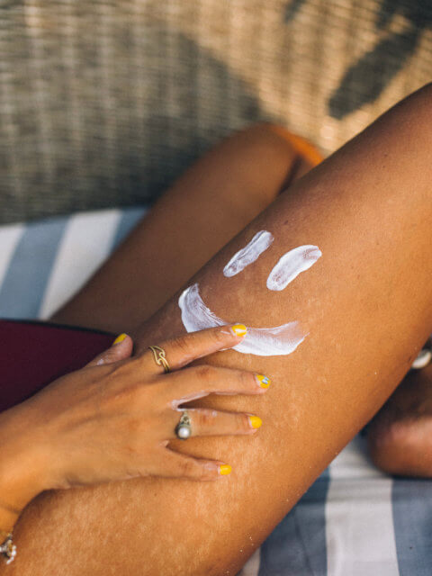 A bottle of sunscreen next to sunglasses for sun protection